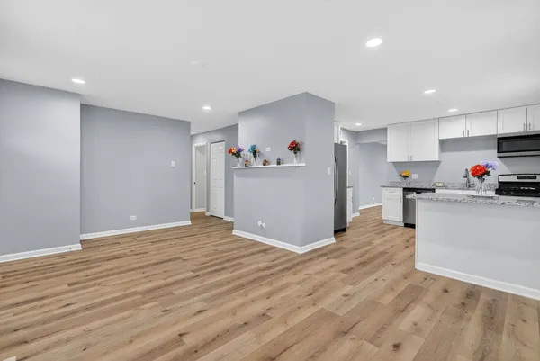 a view of a kitchen with cabinets and wooden floor
