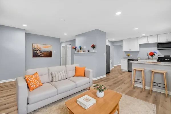 a living room with furniture and a dining table with kitchen view