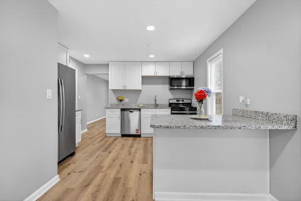 a kitchen with granite countertop a stove a sink and a refrigerator