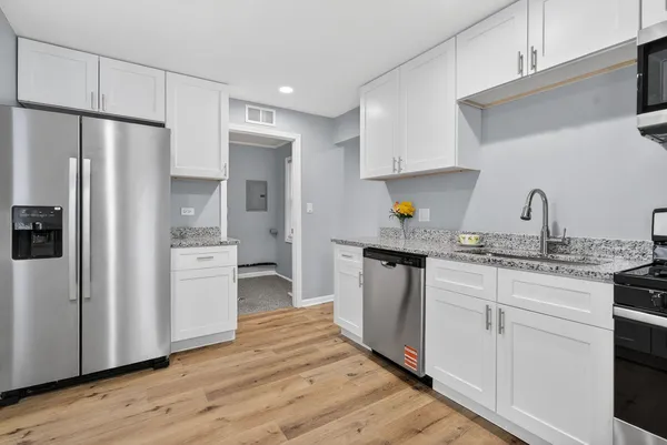 a kitchen with stainless steel appliances a refrigerator sink and cabinets