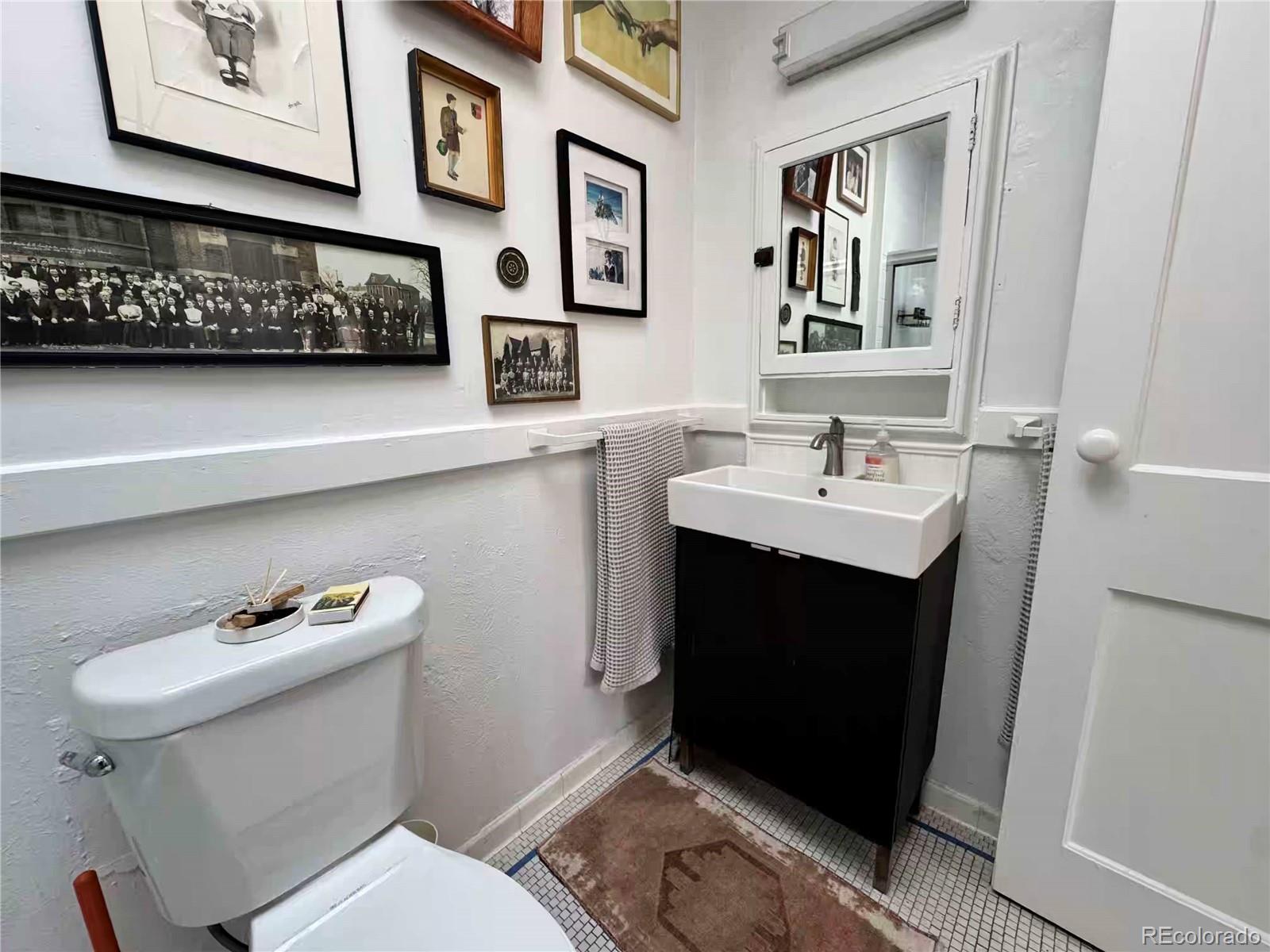 966 Garfield Street Denver, CO 80206 - Photo 11 of 27 a bathroom with a sink a toilet and a mirror