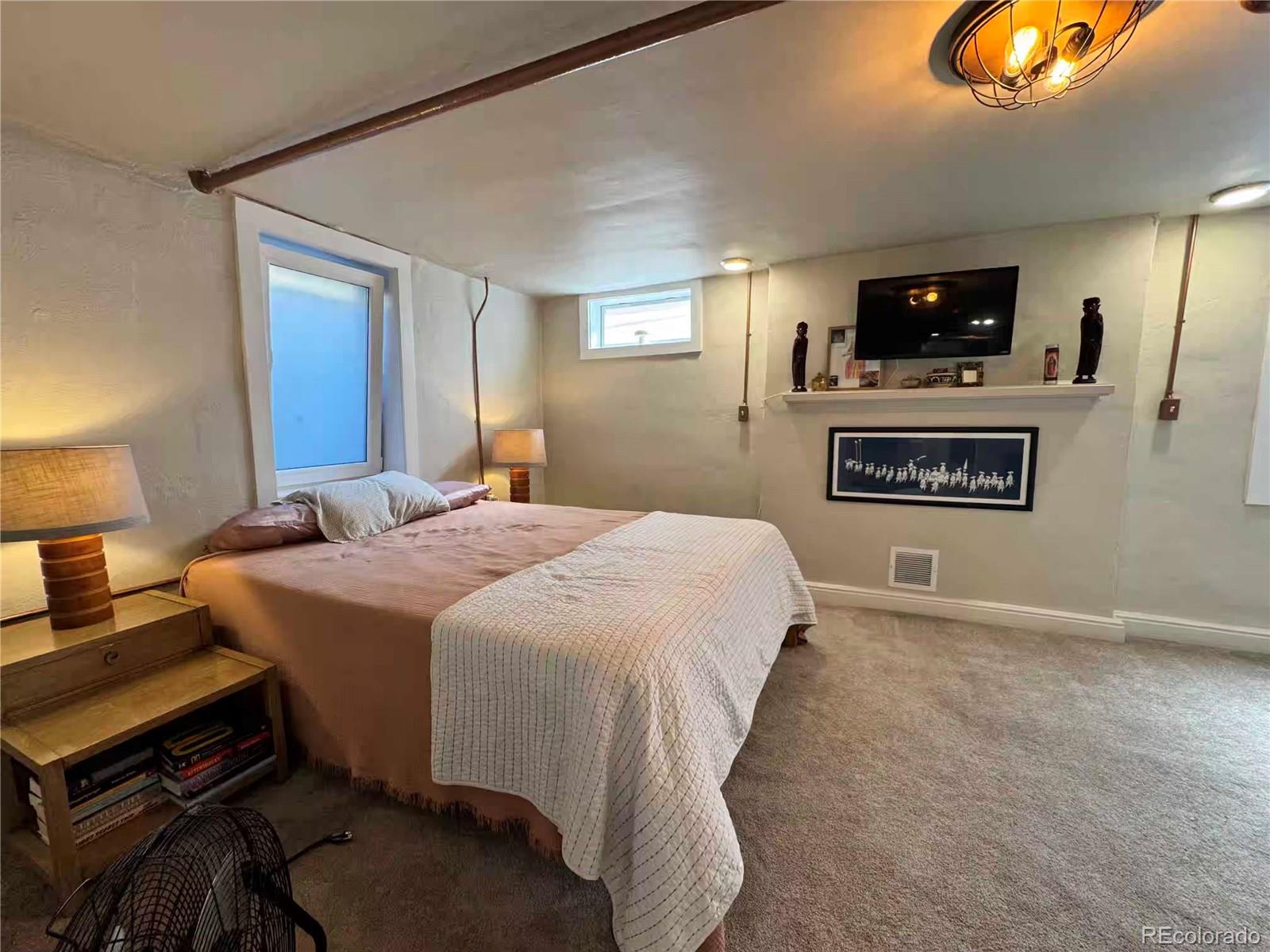 966 Garfield Street Denver, CO 80206 - Photo 18 of 27 a spacious bedroom with a bed and a tv