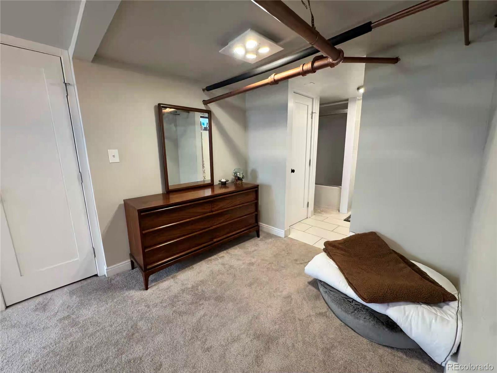 966 Garfield Street Denver, CO 80206 - Photo 22 of 27 a bedroom with a bed and a mirror