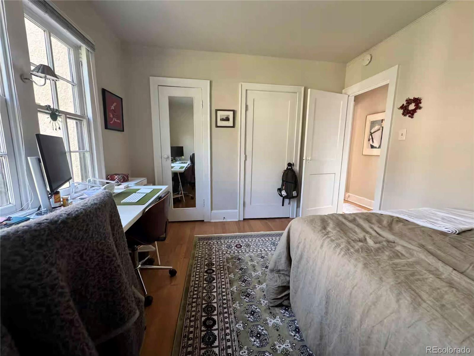 966 Garfield Street Denver, CO 80206 - Photo 7 of 27 a bedroom with a bed and wooden floor