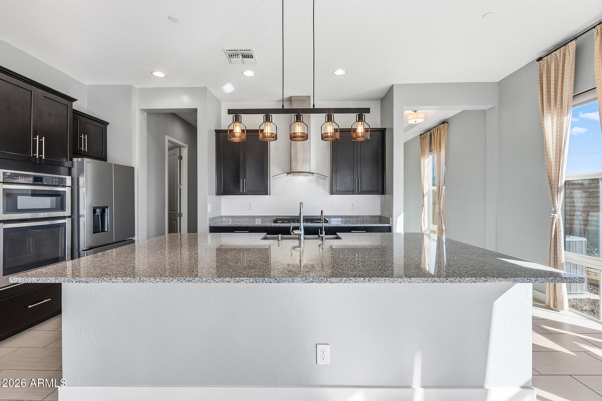 12035 West Roy Rogers Road Peoria, AZ 85383 - Photo 22 of 46 a kitchen with kitchen island a large counter top appliances and cabinets