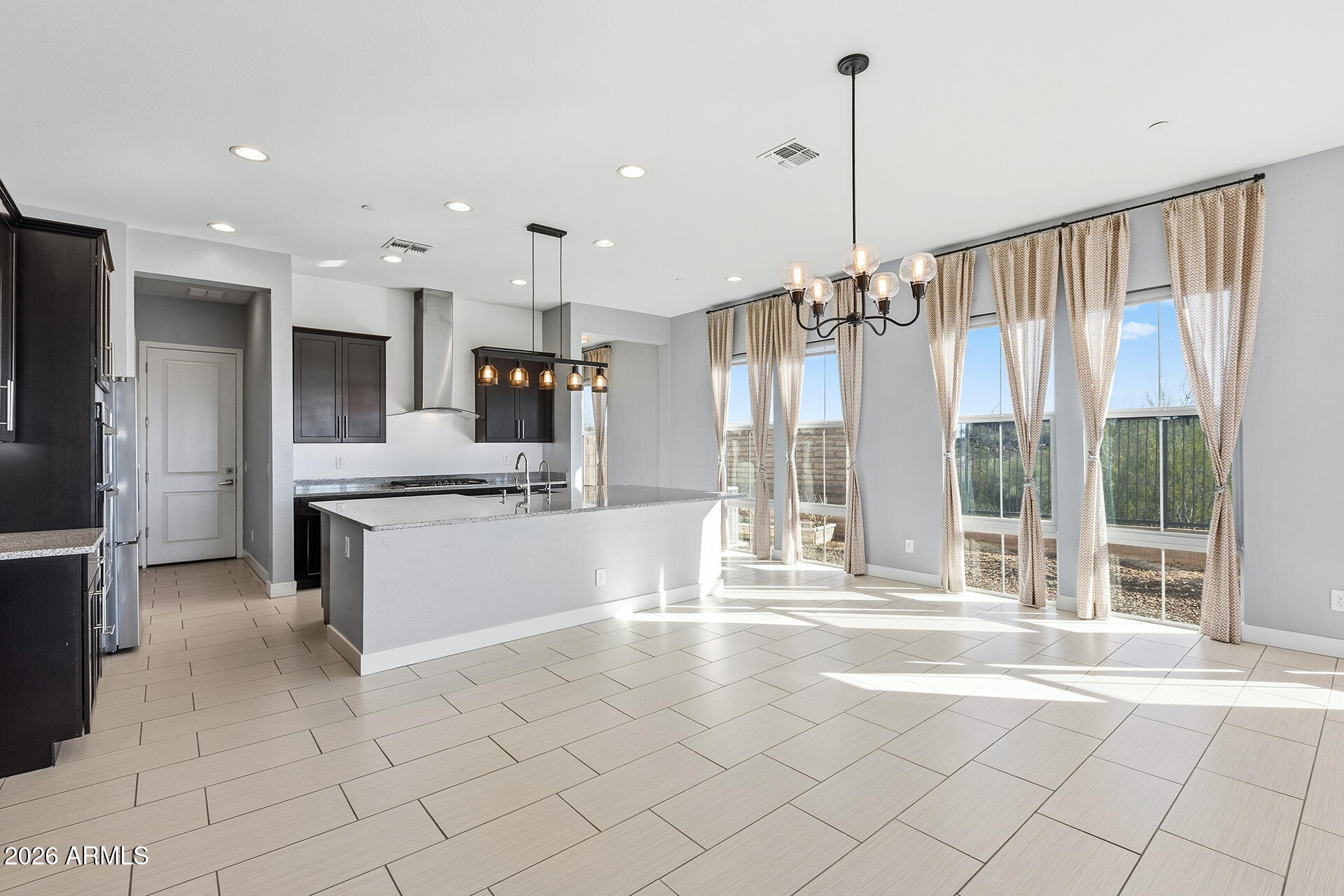 12035 West Roy Rogers Road Peoria, AZ 85383 - Photo 25 of 46 a large kitchen with kitchen island granite countertop a large counter top and stainless steel appliances