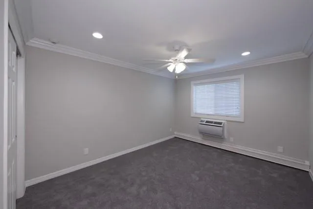 an empty room with windows and fan