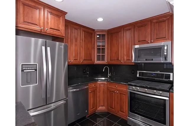 a kitchen with stainless steel appliances granite countertop a refrigerator stove and sink