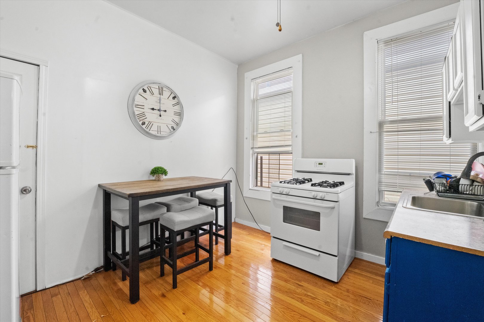 2129 West 18th Place Chicago, IL 60608 - Photo 26 of 38 a view of a dining room and kitchen with a table chairs a stove and wooden floor
