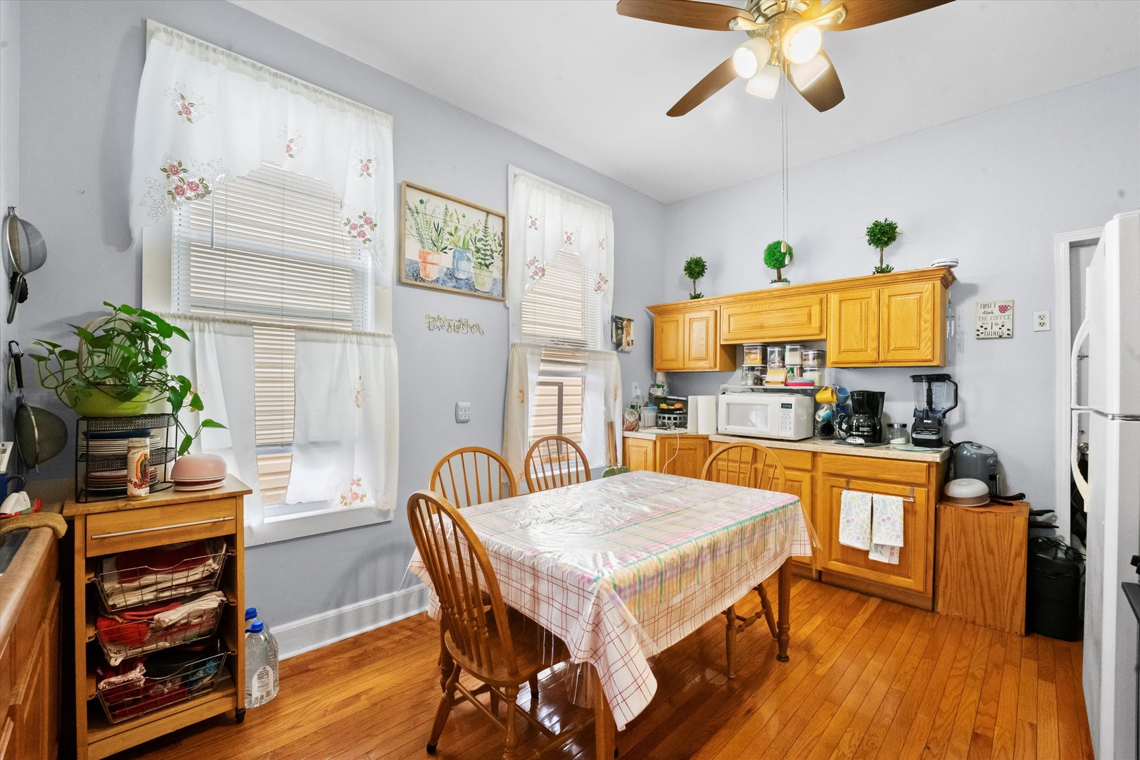 2129 West 18th Place Chicago, IL 60608 - Photo 5 of 38 a kitchen with stainless steel appliances kitchen island granite countertop a table chairs in it and wooden floor