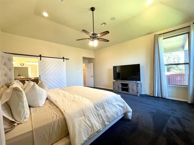 a bedroom with a bed and a flat screen tv