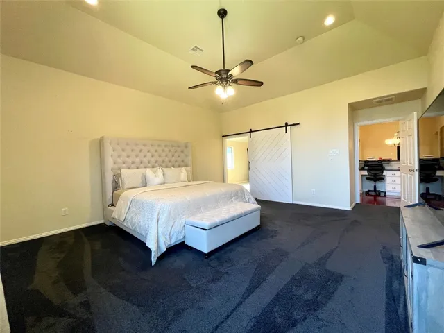 a bed sitting in a spacious bedroom next to a chandelier