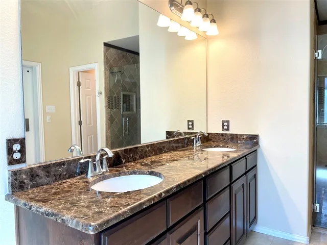a bathroom with a glass door shower and a sink