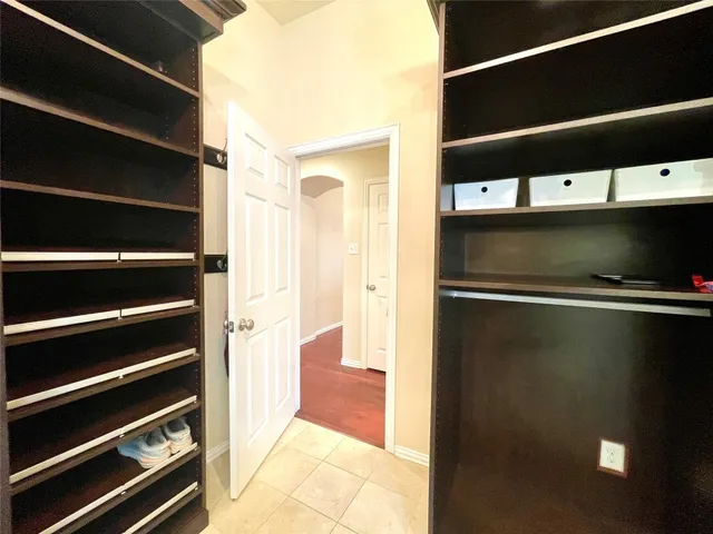 a view of walk in closet with clothes and shoes
