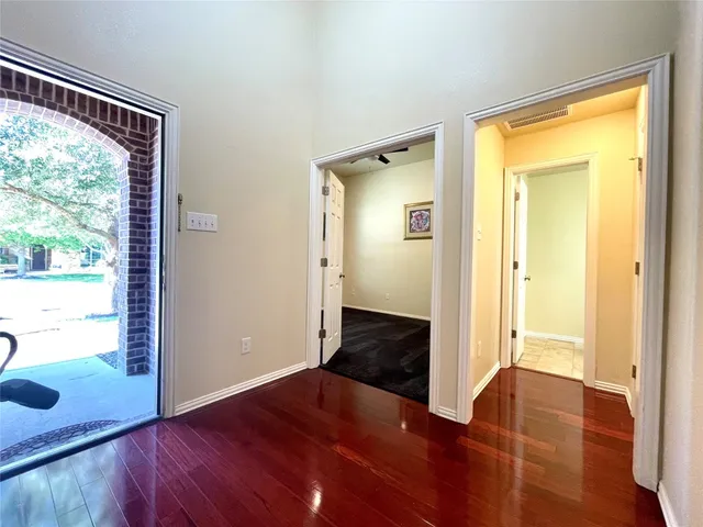 a view of a hallway with wooden floor and windows