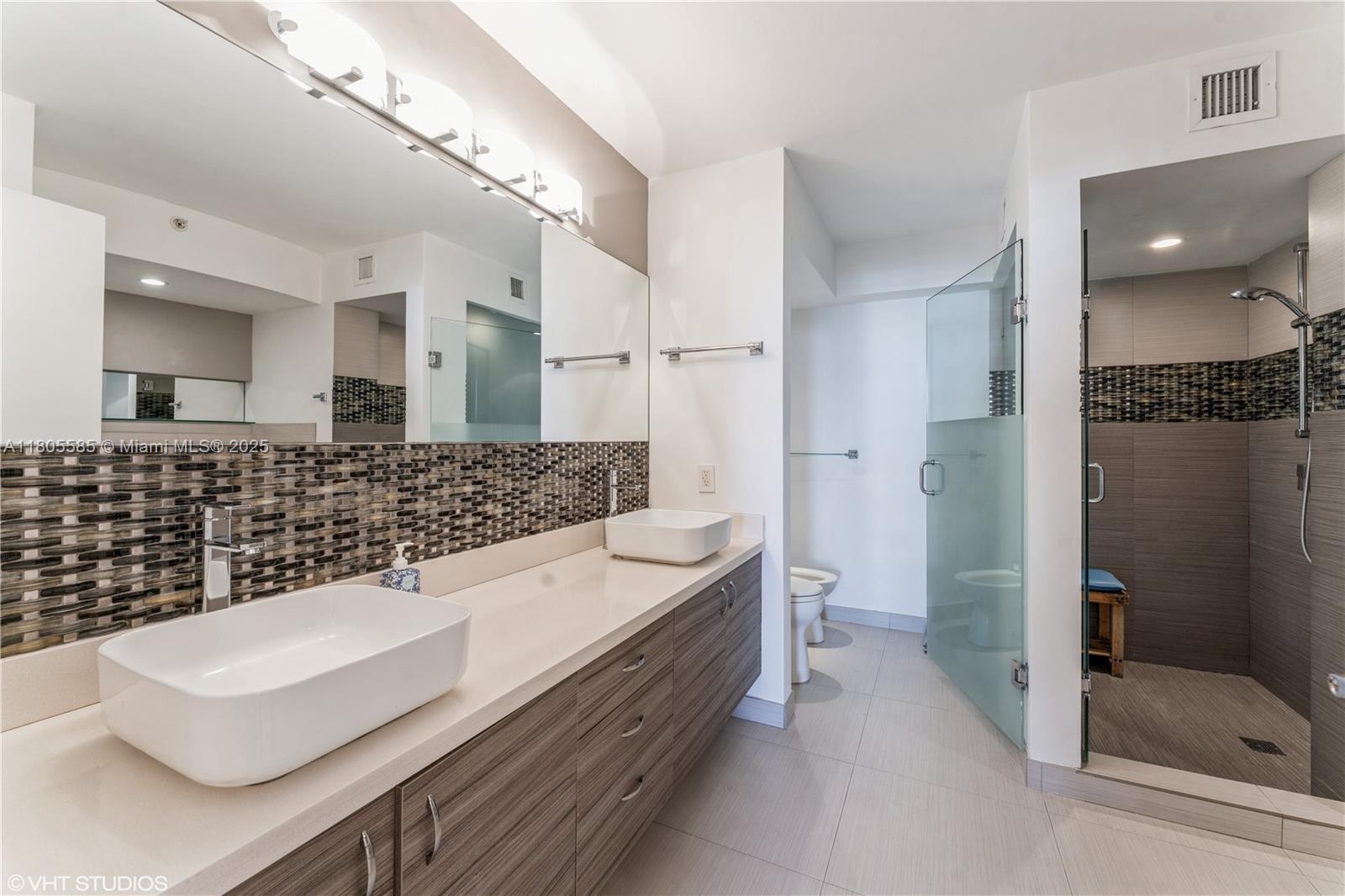 170 Ocean Ln Drive, Unit 906 Key Biscayne, FL 33149 - Photo 15 of 26 a bathroom with a double vanity sink toilet and shower