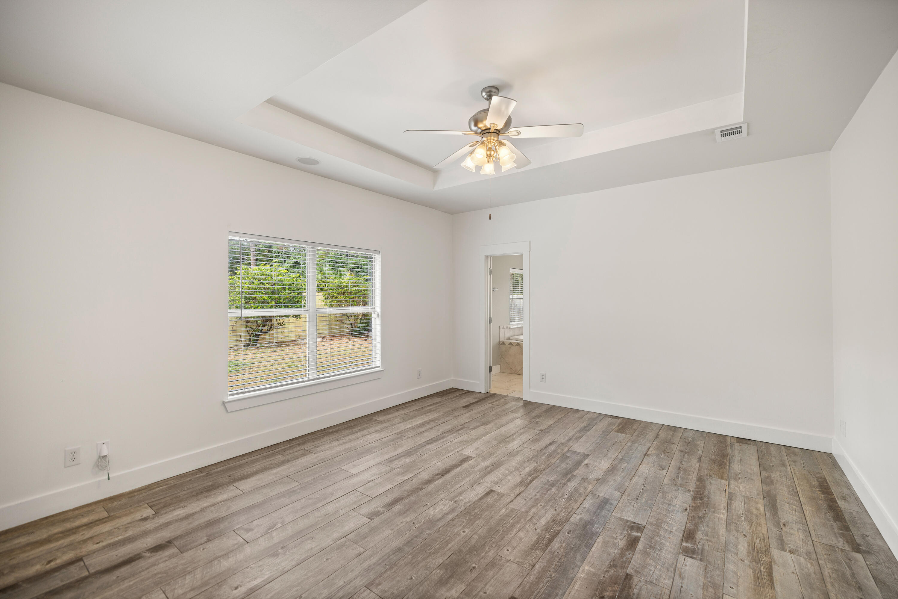 42 Pritchard Road Miramar Beach, FL 32550 - Photo 19 of 51 an empty room with wooden floor chandelier fan and windows