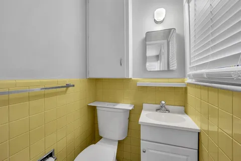a bathroom with a sink mirror and toilet