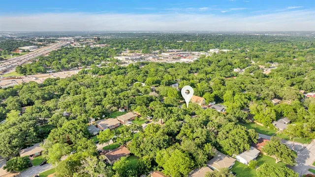 an aerial view of residential houses with outdoor space and trees
