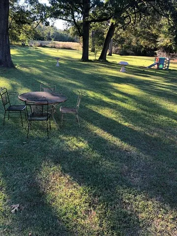 a view of a swimming pool with a yard and outdoor seating