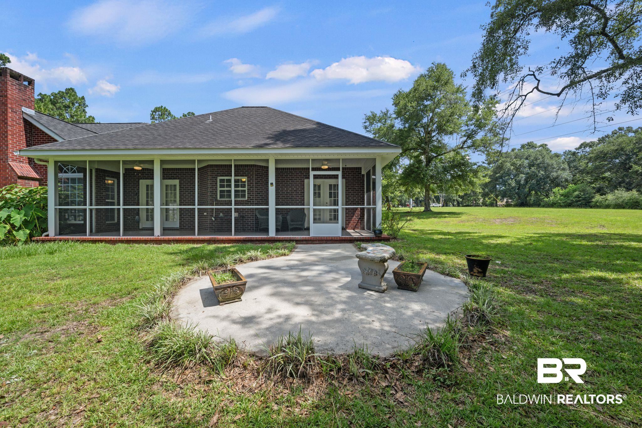 5618 Leytham Road Theodore, AL 36582 - Photo 45 of 60 Rear view of house featuring a patio, a sunroom, and a lawn