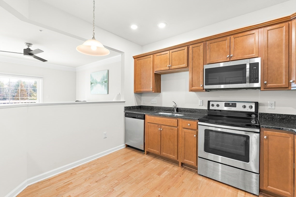 36 Abigail Way, Unit 3003 Reading, MA 01867 - Photo 18 of 42 a kitchen with granite countertop cabinets stainless steel appliances and a window