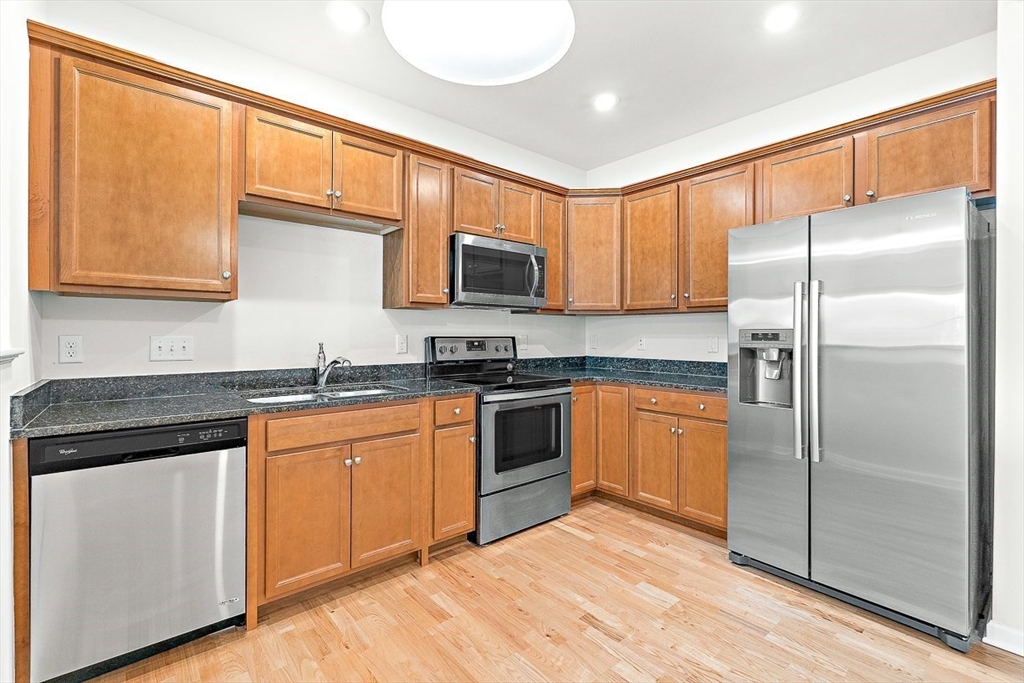 36 Abigail Way, Unit 3003 Reading, MA 01867 - Photo 21 of 42 a kitchen with stainless steel appliances granite countertop a refrigerator stove top oven and sink