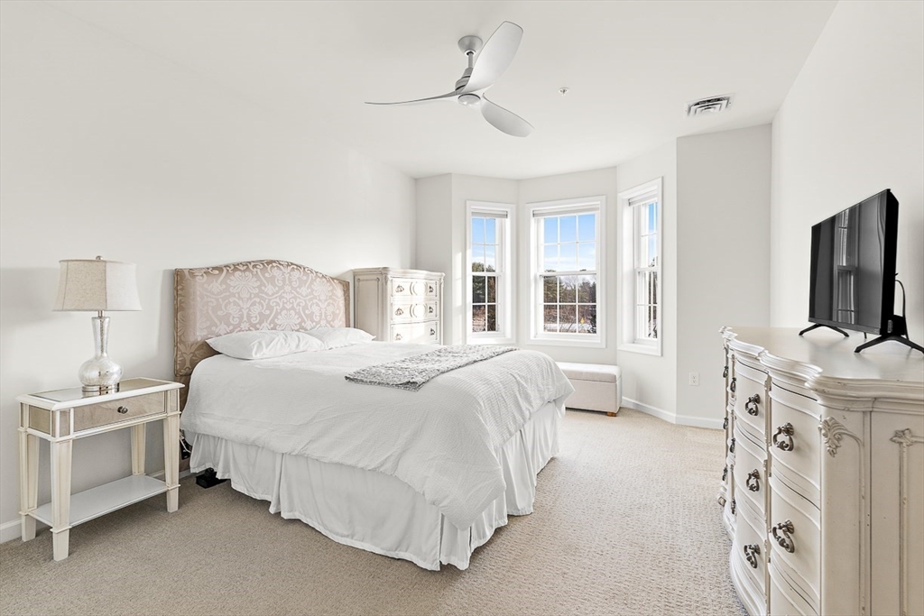 36 Abigail Way, Unit 3003 Reading, MA 01867 - Photo 28 of 42 a bedroom with a bed flat screen tv and a large window
