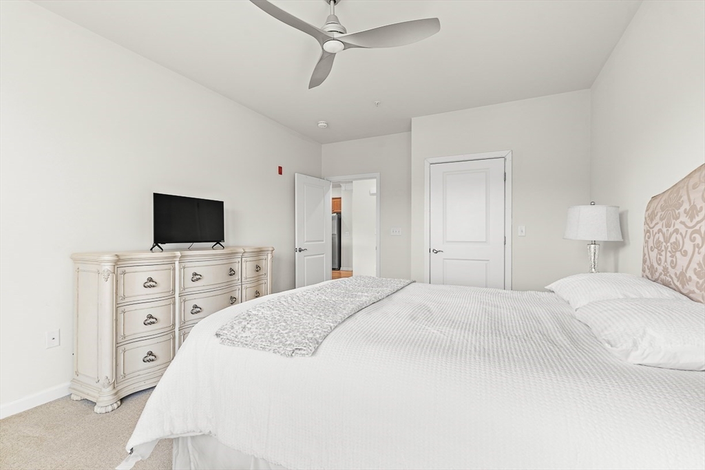 36 Abigail Way, Unit 3003 Reading, MA 01867 - Photo 30 of 42 a spacious bedroom with a bed and a flat screen tv