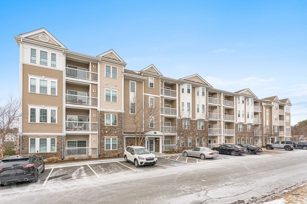 36 Abigail Way, Unit 3003 Reading, MA 01867 - Photo 4 of 42 a front view of a building with lot of cars parked on road