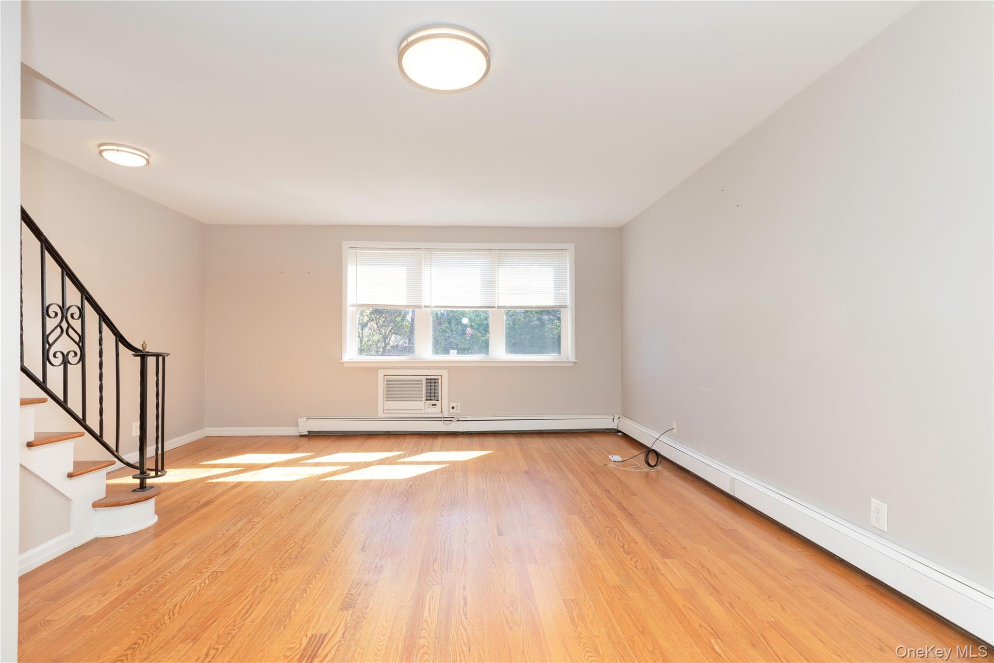 223 Ditmars Street Bronx, NY 10464 - Photo 13 of 28 an empty room with wooden floor and windows