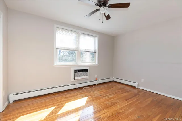 a view of a room with wooden floor and white walls