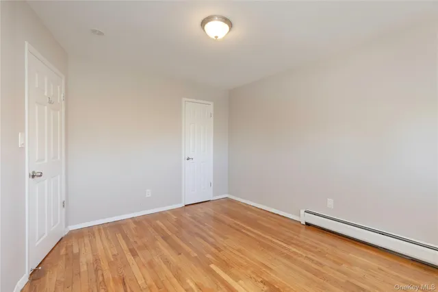 a view of a room with wooden floor and small window
