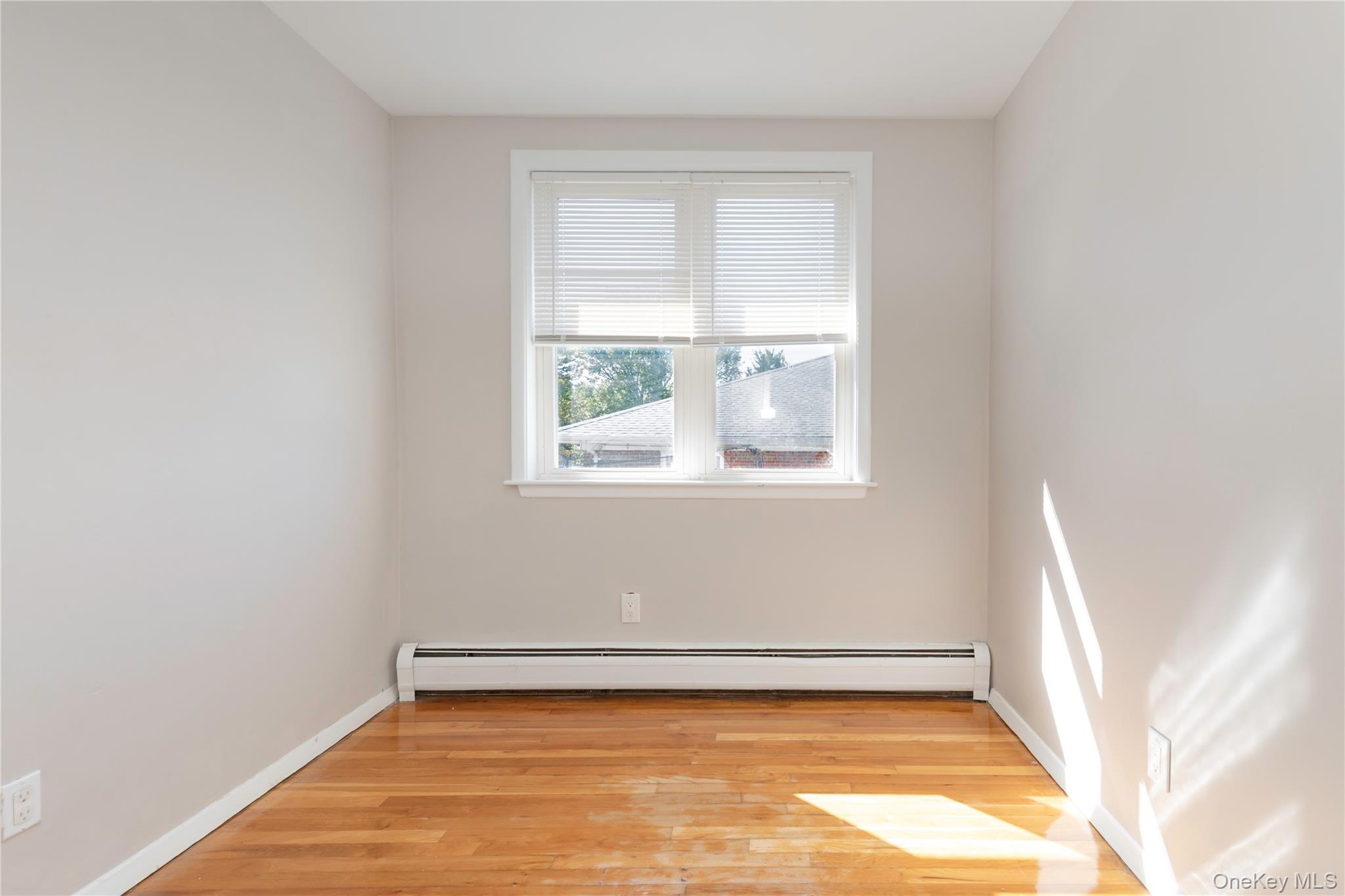 223 Ditmars Street Bronx, NY 10464 - Photo 22 of 28 a view of a room with wooden floor and small window