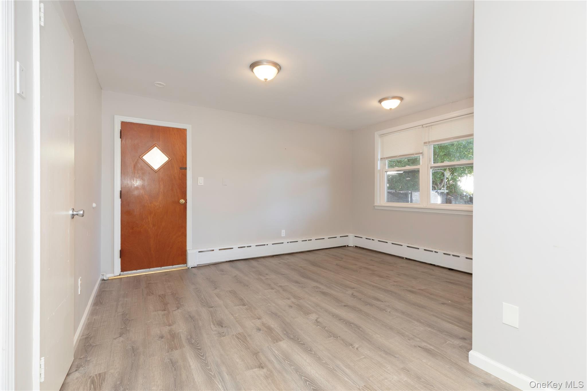 223 Ditmars Street Bronx, NY 10464 - Photo 3 of 28 a view of an empty room with wooden floor and a window