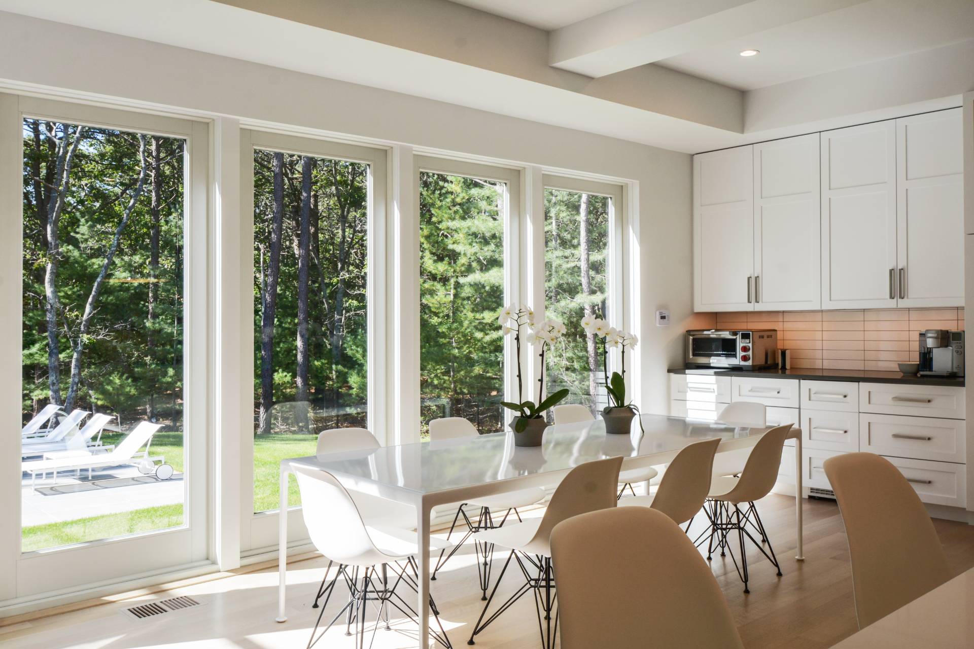 198 Bull Path East Hampton, NY 11937 - Photo 19 of 50 a kitchen with stainless steel appliances granite countertop a stove a refrigerator a table and chairs next to a window