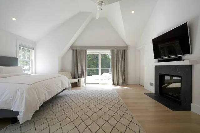 a spacious bedroom with a bed and a flat screen tv