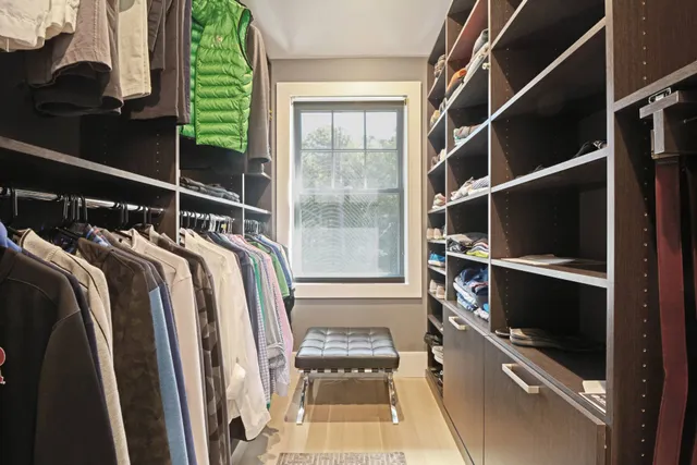 a view of walk in closet with clothes and shoes