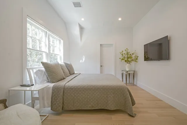 a bedroom with a bed and a flat screen tv
