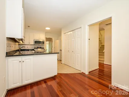 a kitchen with granite countertop a stove sink and refrigerator
