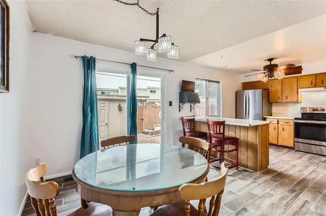 a dining room with wooden floor a chandelier a wooden table and chairs