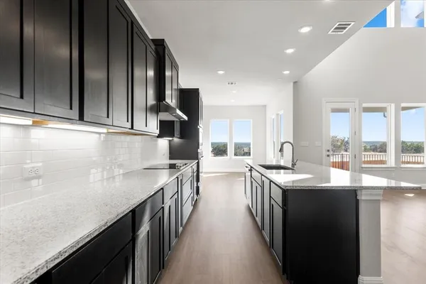 a view of kitchen with kitchen island stainless steel appliances wooden floor and window