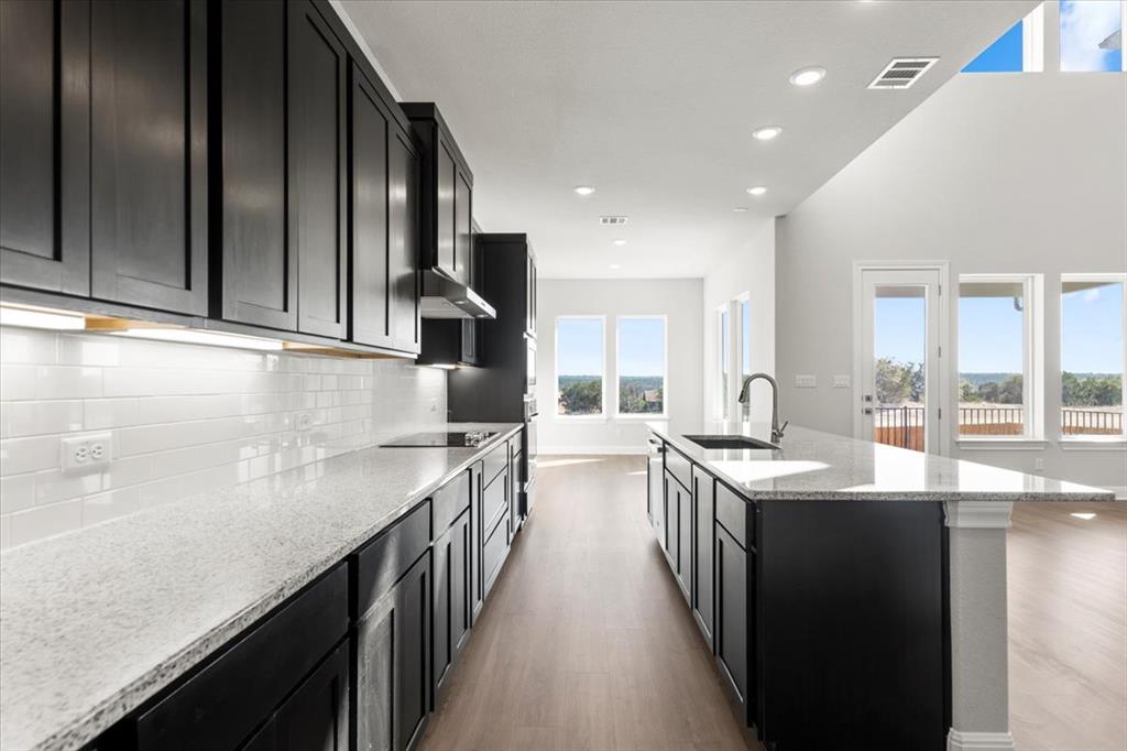 100 Plumfield Cove Georgetown, TX 78628 - Photo 16 of 40 a kitchen with stainless steel appliances granite countertop a sink a stove and a refrigerator