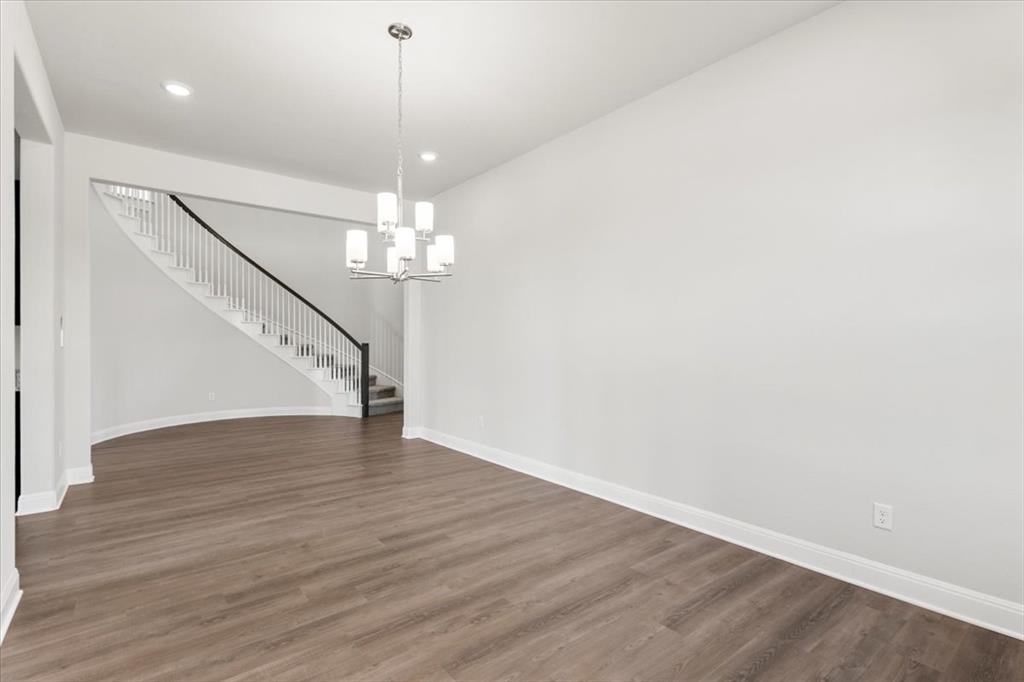 100 Plumfield Cove Georgetown, TX 78628 - Photo 30 of 40 a view of an empty room with wooden floor and chandelier