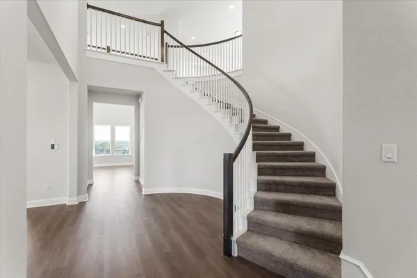 a view of staircase with wooden floor and white walls