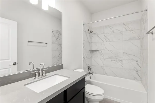 a bathroom with a granite countertop sink toilet tub and shower