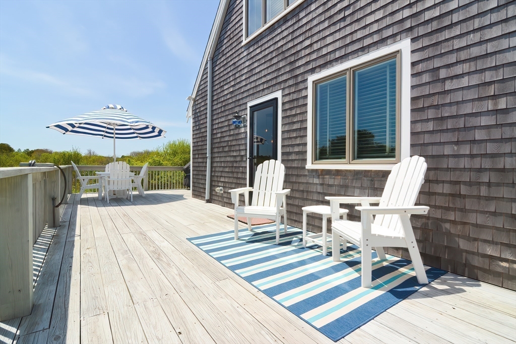 308 Phillips Road Sandwich, MA 02563 - Photo 30 of 42 a view of a patio with table and chairs with wooden floor and fence