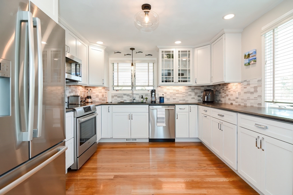 308 Phillips Road Sandwich, MA 02563 - Photo 6 of 42 a kitchen with granite countertop a refrigerator oven a sink dishwasher and white cabinets with wooden floor
