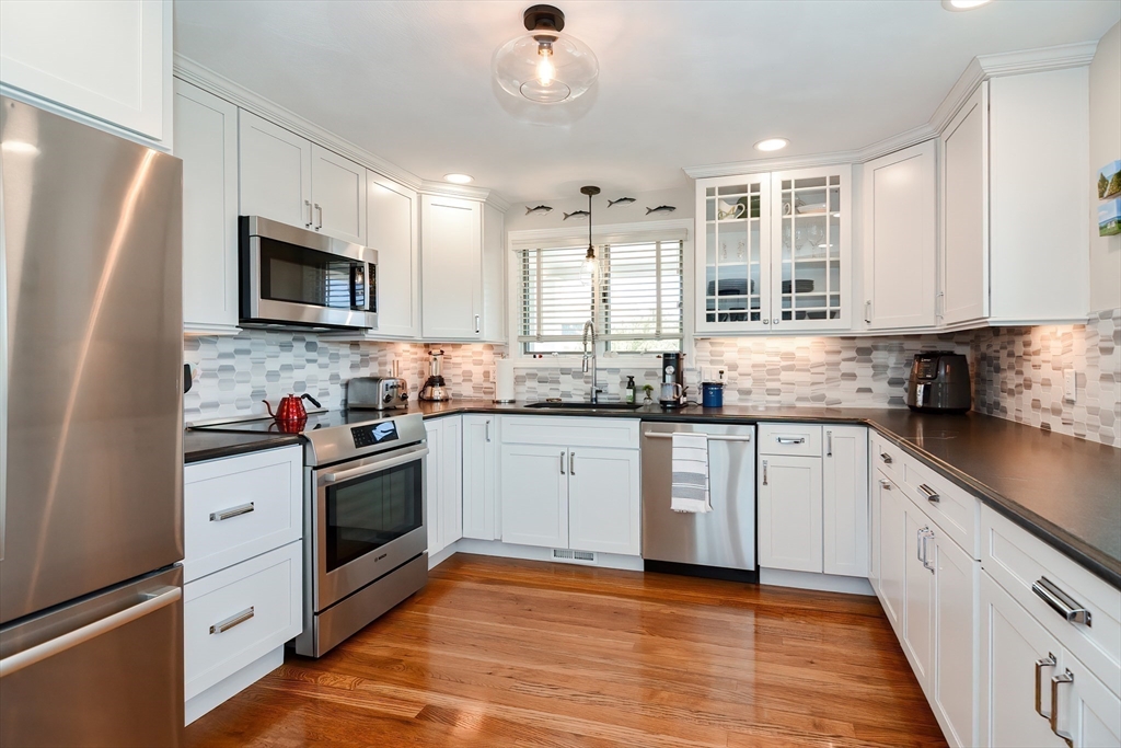308 Phillips Road Sandwich, MA 02563 - Photo 7 of 42 a kitchen with granite countertop a refrigerator a sink dishwasher stove and oven with wooden floor