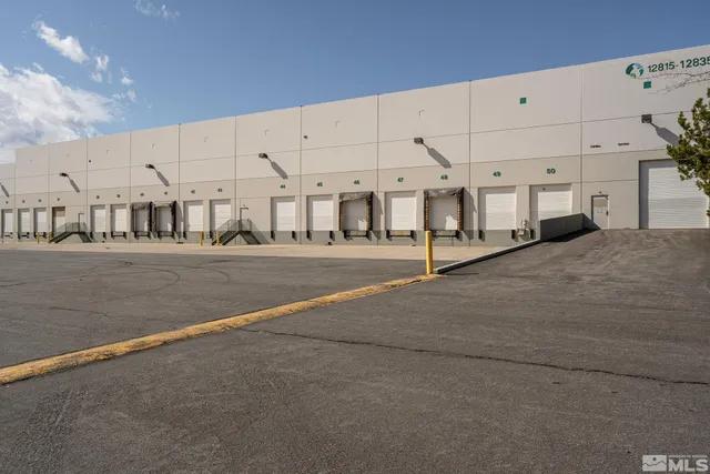 a large white building with a couple of cars parked in front of it